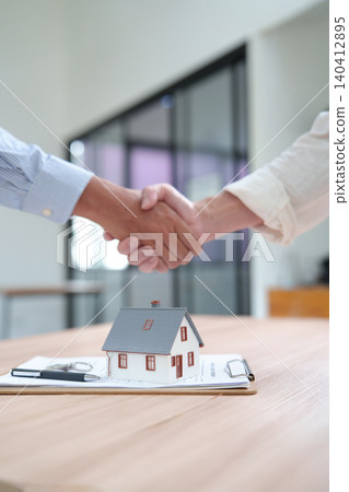 Real estate business deal handshake with house model Real estate business deal handshake with house model 140412895
