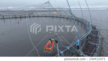 Large fish farm in the water with nets under cloudy sky as background Large fish farm in the water with nets under cloudy sky as background 140412971