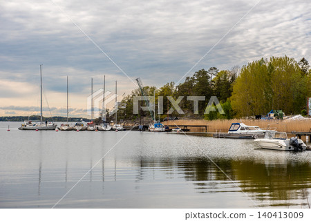 peaceful marina with boats and island shoreline under cloudy sky peaceful marina with boats and island shoreline under cloudy sky 140413009