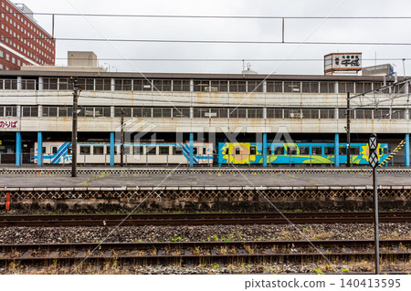一列地方列車和鐵軌停在區域城市的一個車站月台上(側視圖,水平角度)。 一列地方列車和鐵軌停在區域城市的一個車站月台上(側視圖,水平角度)。 140413595