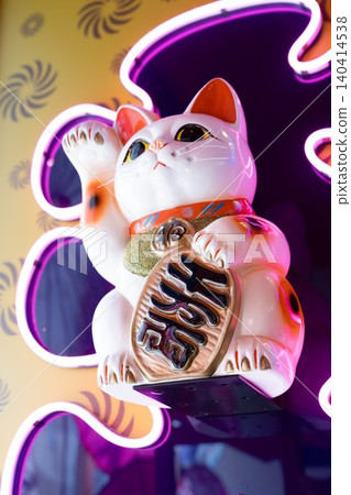 A neon light background and a modern lucky cat figurine. A neon light background and a modern lucky cat figurine. 140414538