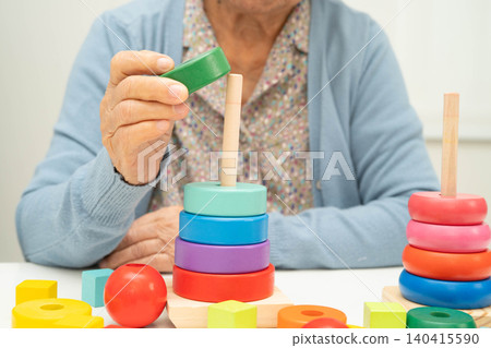 Asian elderly woman playing enhancing skill board game. Asian elderly woman playing enhancing skill board game. 140415590
