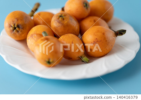 Irregularly shaped, organic, ripe loquats as background material | Natural imperfections and discoloration remain. Irregularly shaped, organic, ripe loquats as background material | Natural imperfections and discoloration remain. 140416379