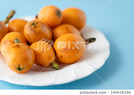 Irregularly shaped, organic, ripe loquats as background material | Natural imperfections and discoloration remain. Irregularly shaped, organic, ripe loquats as background material | Natural imperfections and discoloration remain. 140416380