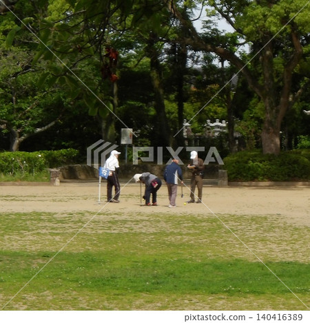 A group of seniors enjoying ground golf in the park's open area. A group of seniors enjoying ground golf in the park's open area. 140416389
