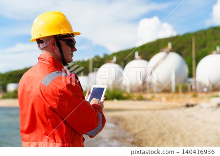 Industrial engineer using digital tablet at oil refinery plant Industrial engineer using digital tablet at oil refinery plant 140416936