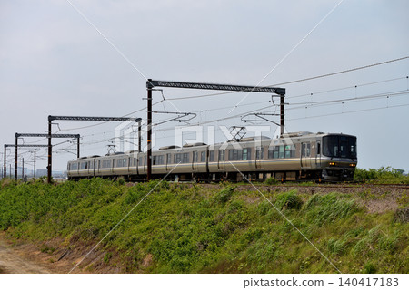 一列由 4 節車廂組成的 223 系列特快列車正在北陸線上運行。 140417183