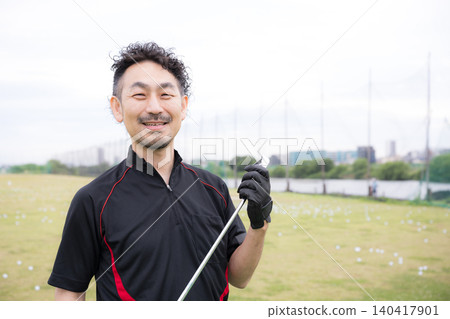 A portrait of a smiling male golfer holding a golf club, looking directly at the camera and smiling while practicing golf. A portrait of a smiling male golfer holding a golf club, looking directly at the camera and smiling while practicing golf. 140417901
