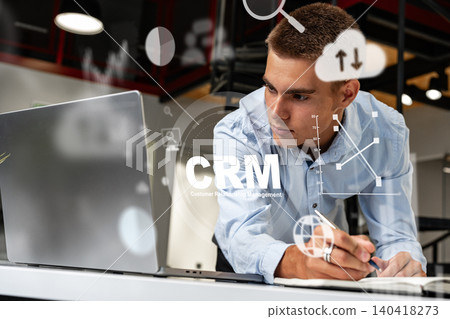 Working on CRM tools to manage customer data in a modern office setting Working on CRM tools to manage customer data in a modern office setting 140418273