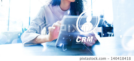 Business professional reviews CRM data on a tablet in a bright office environment Business professional reviews CRM data on a tablet in a bright office environment 140418418