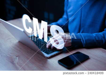 Working on a content management system with a laptop and smartphone in a dark room Working on a content management system with a laptop and smartphone in a dark room 140418499