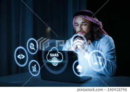 Person uses laptop for Software as a Service tasks in a dark room at night Person uses laptop for Software as a Service tasks in a dark room at night 140418740