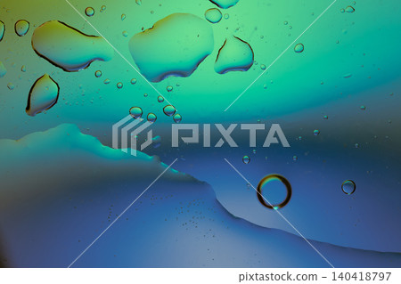 Macro shot of fluid dynamics showing floating oil drops over vibrant, colorful light leaks Macro shot of fluid dynamics showing floating oil drops over vibrant, colorful light leaks 140418797
