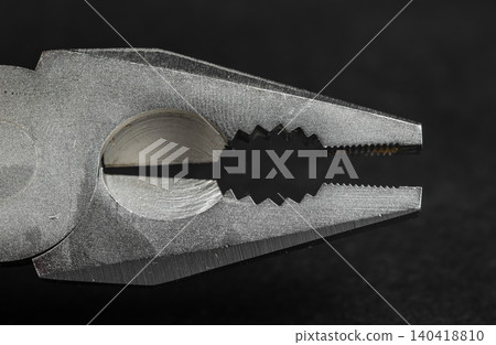 Detail shot of steel wire cutter pliers jaw mechanics over a dark texture 140418810