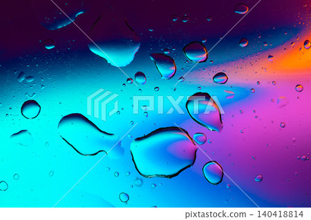 Macro shot of fluid dynamics showing floating oil drops over vibrant, colorful light leaks Macro shot of fluid dynamics showing floating oil drops over vibrant, colorful light leaks 140418814