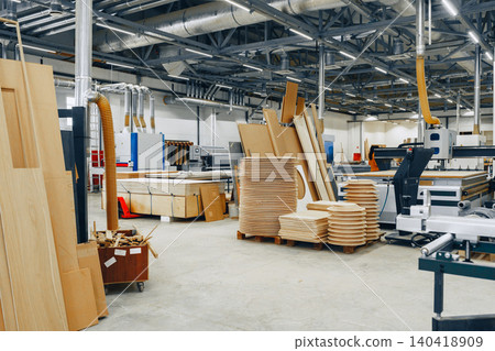 Furniture workshop with machines and materials in a busy space for woodworking projects Furniture workshop with machines and materials in a busy space for woodworking projects 140418909