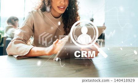 Woman working on tablet with CRM software in modern office space in daylight hours Woman working on tablet with CRM software in modern office space in daylight hours 140418929