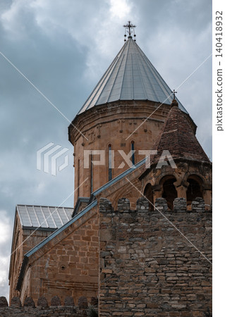Low angle view of an ancient stone cathedral dome and fortified wall under dramatic clouds Low angle view of an ancient stone cathedral dome and fortified wall under dramatic clouds 140418932