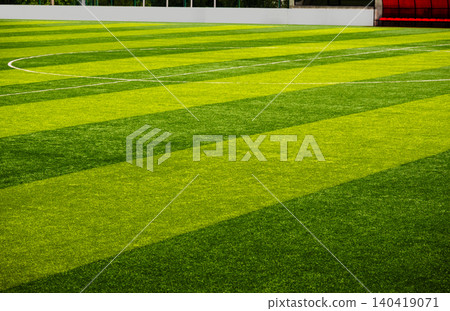 Wide perspective of an empty artificial turf football pitch with green stripes and white lines Wide perspective of an empty artificial turf football pitch with green stripes and white lines 140419071