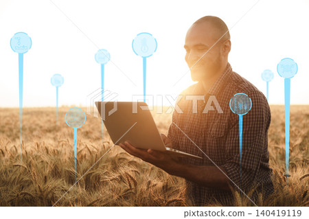 Smart farm worker uses laptop to monitor field data in evening sunlight Smart farm worker uses laptop to monitor field data in evening sunlight 140419119