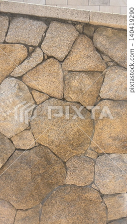 Vertical natural stone wall texture with irregular shapes and warm earthy tones Vertical natural stone wall texture with irregular shapes and warm earthy tones 140419290
