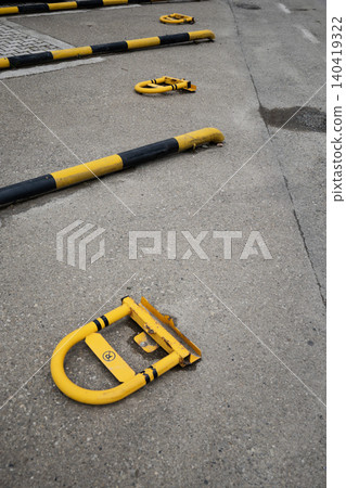 High angle view of yellow folding parking bollards on gray pavement with soft daylight High angle view of yellow folding parking bollards on gray pavement with soft daylight 140419322