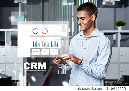 Man using smartphone to view CRM software in modern office setting during daytime hours 140419353