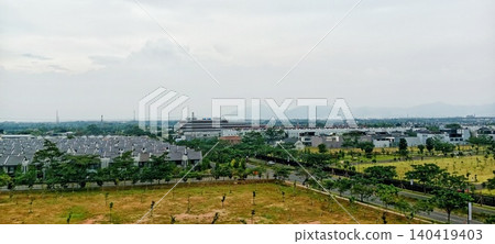 View of a modern housing complex with a misty mountain backdrop View of a modern housing complex with a misty mountain backdrop 140419403