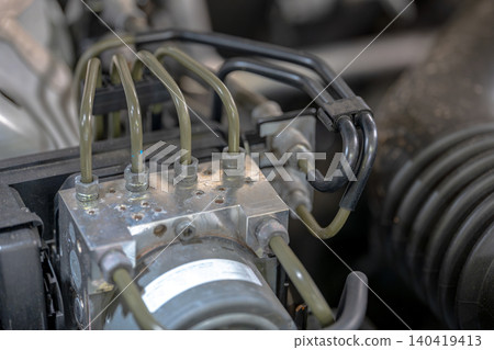 Various pipes connect to an engine component in a vehicle's engine area. Various pipes connect to an engine component in a vehicle's engine area. 140419413