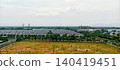 Row of houses with gray roofs and vast green land 140419451