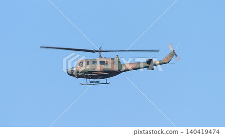一架日本陸上自衛隊的UH-1J直升機在藍天中飛行。 一架日本陸上自衛隊的UH-1J直升機在藍天中飛行。 140419474