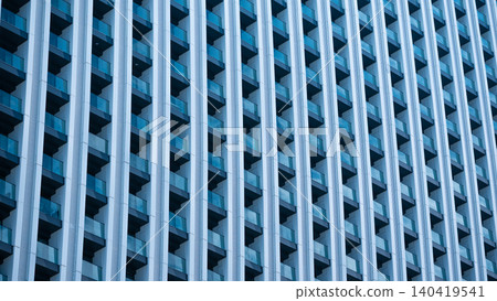 Repetitive geometric pattern of glass balconies on a large contemporary residential building 140419541