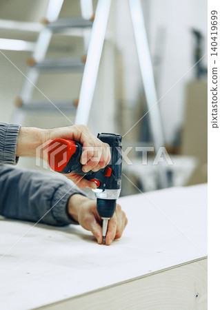 Creating furniture at a workshop with a power drill and wood Creating furniture at a workshop with a power drill and wood 140419699
