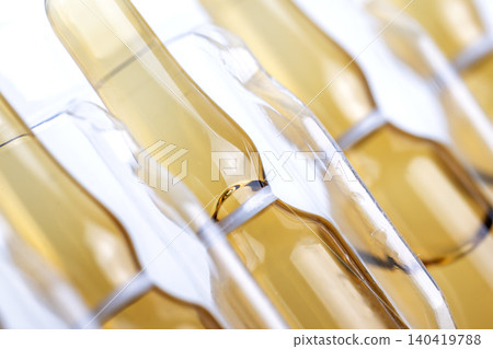 Close-up of amber glass vials held in a clear plastic tray, diagonal composition Close-up of amber glass vials held in a clear plastic tray, diagonal composition 140419788