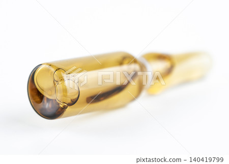 Extreme close-up with shallow depth of field focusing on the bottom of a yellow glass vial Extreme close-up with shallow depth of field focusing on the bottom of a yellow glass vial 140419799