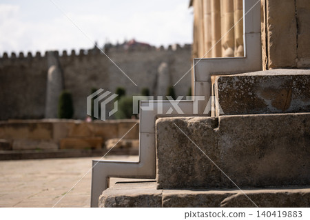 Contrast between modern metal guttering and weathered medieval stone stairs in a courtyard Contrast between modern metal guttering and weathered medieval stone stairs in a courtyard 140419883