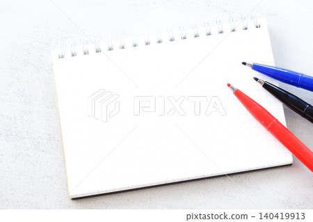 An image of doing desk work with a ring-type notepad and pen 140419913