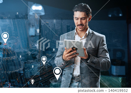Man using tablet to plan taxi route on city map with location markers in daytime Man using tablet to plan taxi route on city map with location markers in daytime 140419932