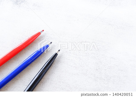 Three pens, blue, red and black, on a desk Three pens, blue, red and black, on a desk 140420051