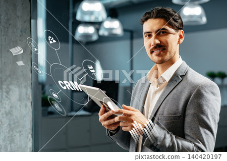 Man uses tablet to manage customer relationships in modern office space 140420197