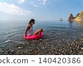 Woman floating pink tube swimming vacation sea Summer leisure activity on pebble beach enjoying bright sunny day 140420386