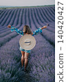 Lavender field woman standing with arms outstretched in blooming purple flowers during golden hour summer travel concept 140420427