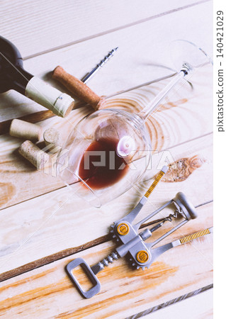 Wine bottle and glasses with corks and corkscrew on wooden table Wine bottle and glasses with corks and corkscrew on wooden table 140421029