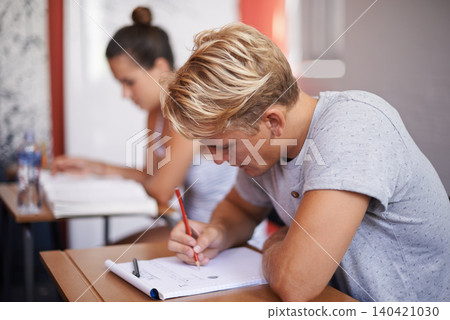 Man, student and writing with book in classroom for studying, reading or summary at university. Male person or academic writer taking notes for assignment, test or literature exam on desk at campus Man, student and writing with book in classroom for studying, reading or summary at university. Male person or academic writer taking notes for assignment, test or literature exam on desk at campus 140421030