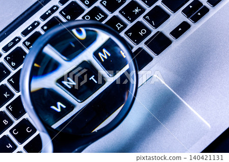Looking closely at a laptop keyboard with a magnifying glass shows letters in detail Looking closely at a laptop keyboard with a magnifying glass shows letters in detail 140421131
