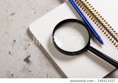 Tools for studying and examining notes on a flat surface with a notebook and pen present Tools for studying and examining notes on a flat surface with a notebook and pen present 140421427