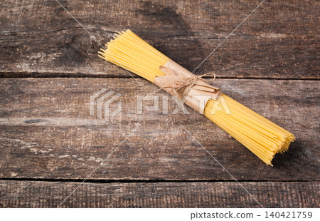 Spaghetti tied with string on wooden table ready for cooking Spaghetti tied with string on wooden table ready for cooking 140421759