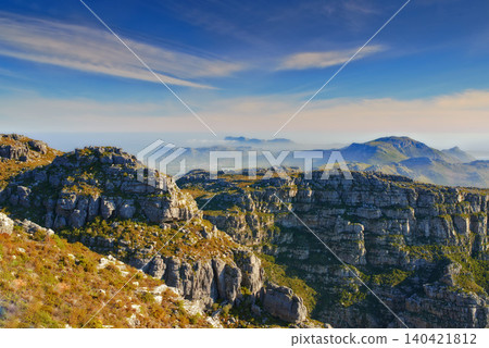 Mountains, blue sky and natural landscape with clouds, cliff and calm location for travel destination. Nature, fog and sustainable environment with earth, peace and holiday with sunset on horizon. Mountains, blue sky and natural landscape with clouds, cliff and calm location for travel destination. Nature, fog and sustainable environment with earth, peace and holiday with sunset on horizon. 140421812