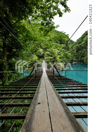 A view overlooking the emerald green lake surface from the "Dream Suspension Bridge" in Sumatakyo Gorge, Kawanehoncho, Shizuoka Prefecture. A view overlooking the emerald green lake surface from the "Dream Suspension Bridge" in Sumatakyo Gorge, Kawanehoncho, Shizuoka Prefecture. 140421825
