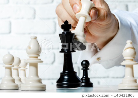 Chess game in progress with a player making a move on a board during a match Chess game in progress with a player making a move on a board during a match 140421903